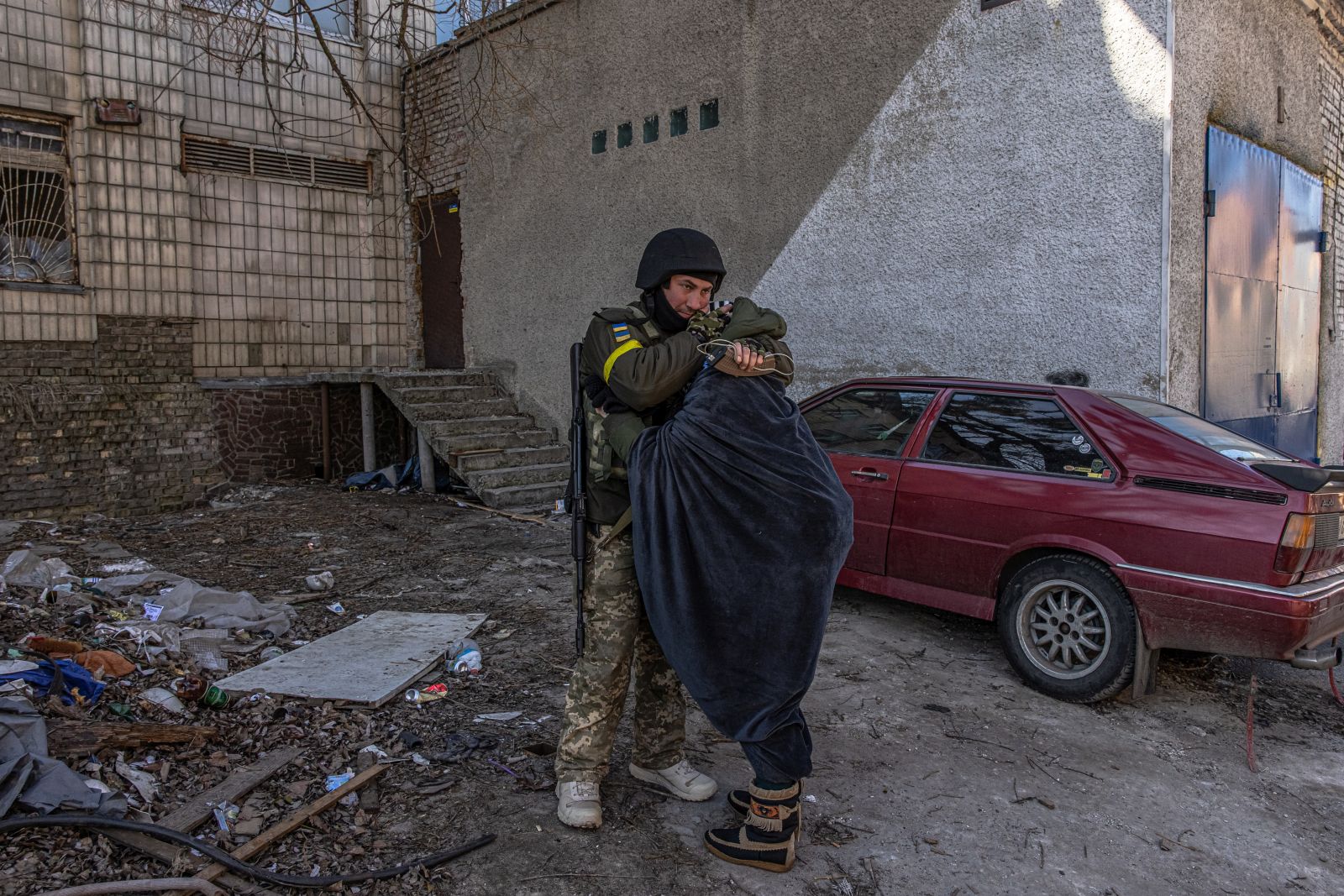 epa09815762 A Ukrainian soldier hugs a woman as residents are evacuated from the frontline town of Irpin, Kyiv (Kiev) region, Ukraine, 10 March 2022. Thousands of residents are feeling Irpin and Bucha, as well as other settlements near Kyiv which were the most affected by the Russian army invasion.  EPA/ROMAN PILIPEY