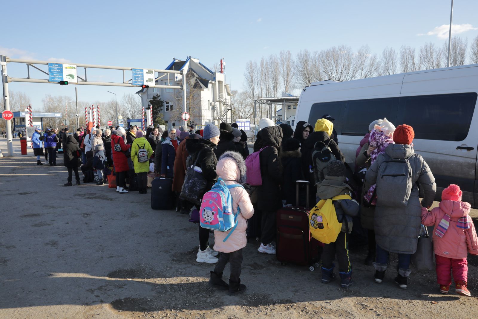 epa09819711 Ukrainians fleeing the conflict prepare to board a minibus at the border crossing between Ukraine and Moldova, at Palanca, Moldova, 12 March 2022. The Minibus takes them to a reception center nearby where they can get a warm drink then take a bus for Romania, Poland, Germany or the capital city Chisinau. Sixteen days into the Russian invasion of Ukraine the numbers of refugees fleeing the conflict to neighboring countries continues to be high with more than 2 million going to Poland, Slovakia, Romania and Moldova then to other EU countries for a number of them, according to the UNHCR. Moldova has so far seen some 300,000 refugees transiting to other EU countries, 84,000  of them staying in the country.  EPA/AMEL PAIN