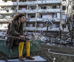 epaselect epa09826875 A woman sits next to debris of a building damaged by shelling in Kyiv, Ukraine, 15 March 2022. On 24 February Russian troops had entered Ukrainian territory in what the Russian president declared a 'special military operation', resulting in fighting and destruction in the country, a huge flow of refugees, and multiple sanctions against Russia.  EPA/MIGUEL A. LOPES