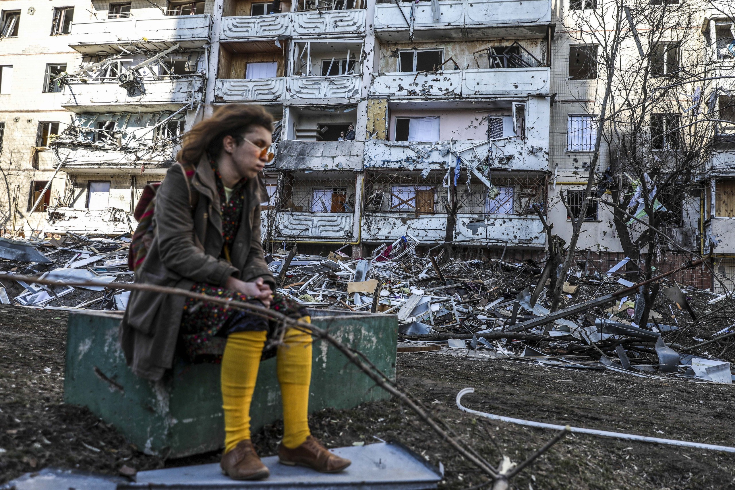 epaselect epa09826875 A woman sits next to debris of a building damaged by shelling in Kyiv, Ukraine, 15 March 2022. On 24 February Russian troops had entered Ukrainian territory in what the Russian president declared a 'special military operation', resulting in fighting and destruction in the country, a huge flow of refugees, and multiple sanctions against Russia.  EPA/MIGUEL A. LOPES
