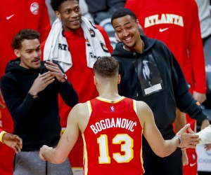 epa09834958 Atlanta Hawks guard Bogdan Bogdanovic (C) of Serbia is greeted by injured Hawks players Trae Young (L) and John Collins (R) during the second half of the NBA basketball game between the Memphis Grizzlies and the Atlanta Hawks at State Farm Arena in Atlanta, Georgia, USA, 18 March 2022.  EPA/ERIK S. LESSER  SHUTTERSTOCK OUT