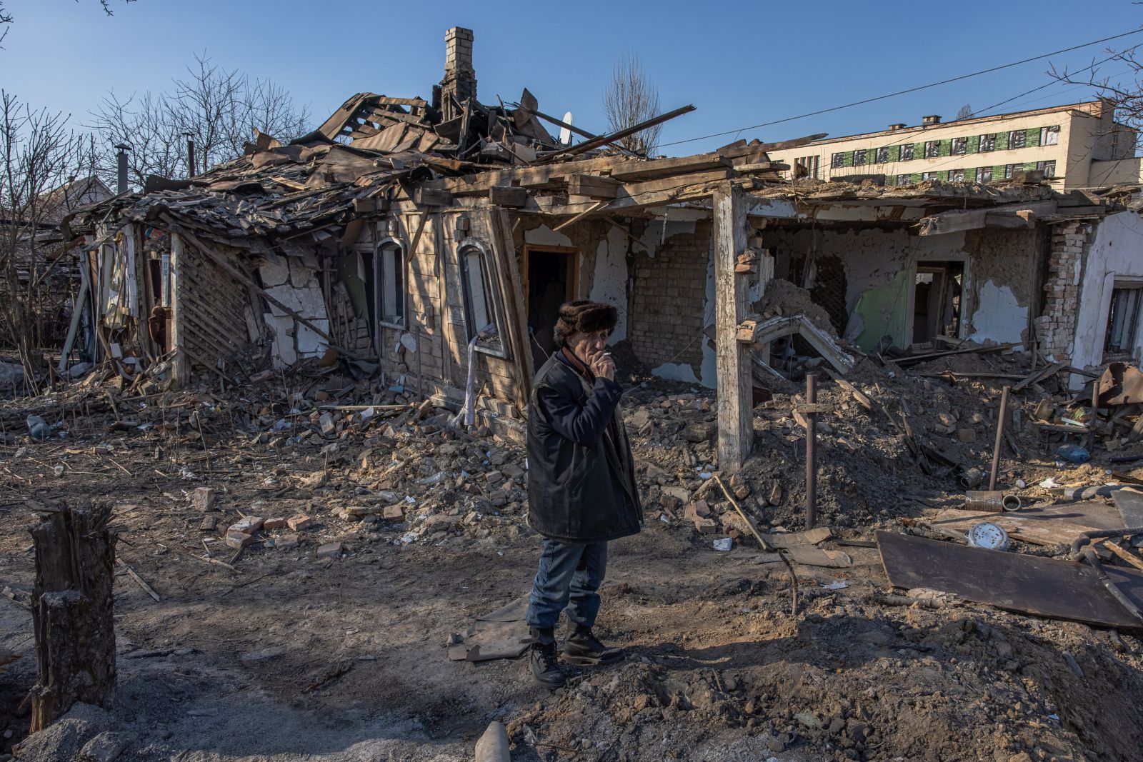 epa09839488 Ihor (67), smokes next to his severely damaged house after the Russian shelling, in Zhytomyr city, north-west Ukraine, 20 March 2022. Russian troops entered Ukraine on 24 February resulting in fighting and destruction in the country, and triggering a series of severe economic sanctions on Russia by Western countries.  EPA/ROMAN PILIPEY