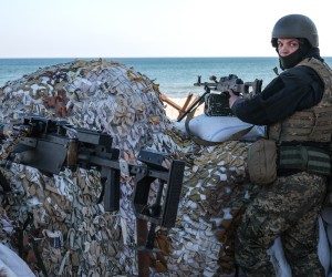 epa09840841 A Ukrainian soldier stands guard with his gun  next to barricades at the beachfront near Lusanivka in south Ukrainian city of Odesa, in Ukraine, 21 March 2022. Russian troops entered Ukraine on 24 February prompting the country's president to declare martial law and triggering a series of announcements by Western countries to impose severe economic sanctions on Russia.  EPA/SEDAT SUNA