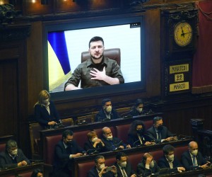 epa09841818 Ukrainian President Volodymyr Zelensky (on screen) addresses members of the Italian Parliament via video conference during an extraordinary Plenary session debating on the 'Russian aggression against Ukraine', at the Italian Parliament in Rome, Italy, 22 March 2022. On 24 February Russian troops had entered Ukrainian territory in what the Russian president declared a 'special military operation', resulting in fighting and destruction in the country, a huge flow of refugees, and multiple sanctions against Russia.  EPA/ALESSANDRO DI MEO