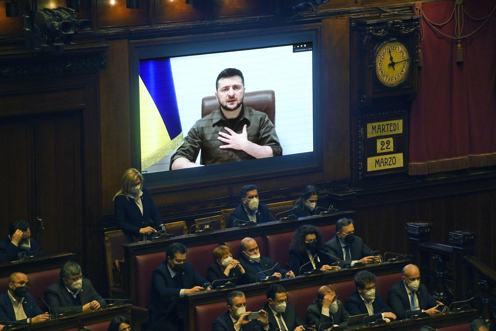 epa09841818 Ukrainian President Volodymyr Zelensky (on screen) addresses members of the Italian Parliament via video conference during an extraordinary Plenary session debating on the 'Russian aggression against Ukraine', at the Italian Parliament in Rome, Italy, 22 March 2022. On 24 February Russian troops had entered Ukrainian territory in what the Russian president declared a 'special military operation', resulting in fighting and destruction in the country, a huge flow of refugees, and multiple sanctions against Russia.  EPA/ALESSANDRO DI MEO