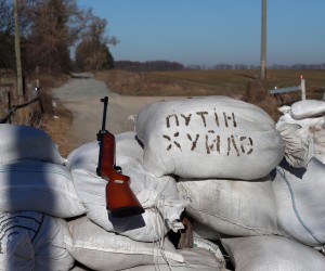 epa09842697 A weapon near a sandbags with words 'Putin is a dick', as members of the civil territorial defence unit control a checkpoint at a road to Zhytomyr, in Mala Racha village, Ukraine, 22 March 2022, as Russia's attack on Ukraine continues. Most of the civilians in this unit don't have military training or weapons experience but they are ready do defend their land. Russian troops entered Ukraine on 24 February resulting in fighting and destruction in the country, and triggering a series of severe economic sanctions on Russia by Western countries.  EPA/NUNO VEIGA