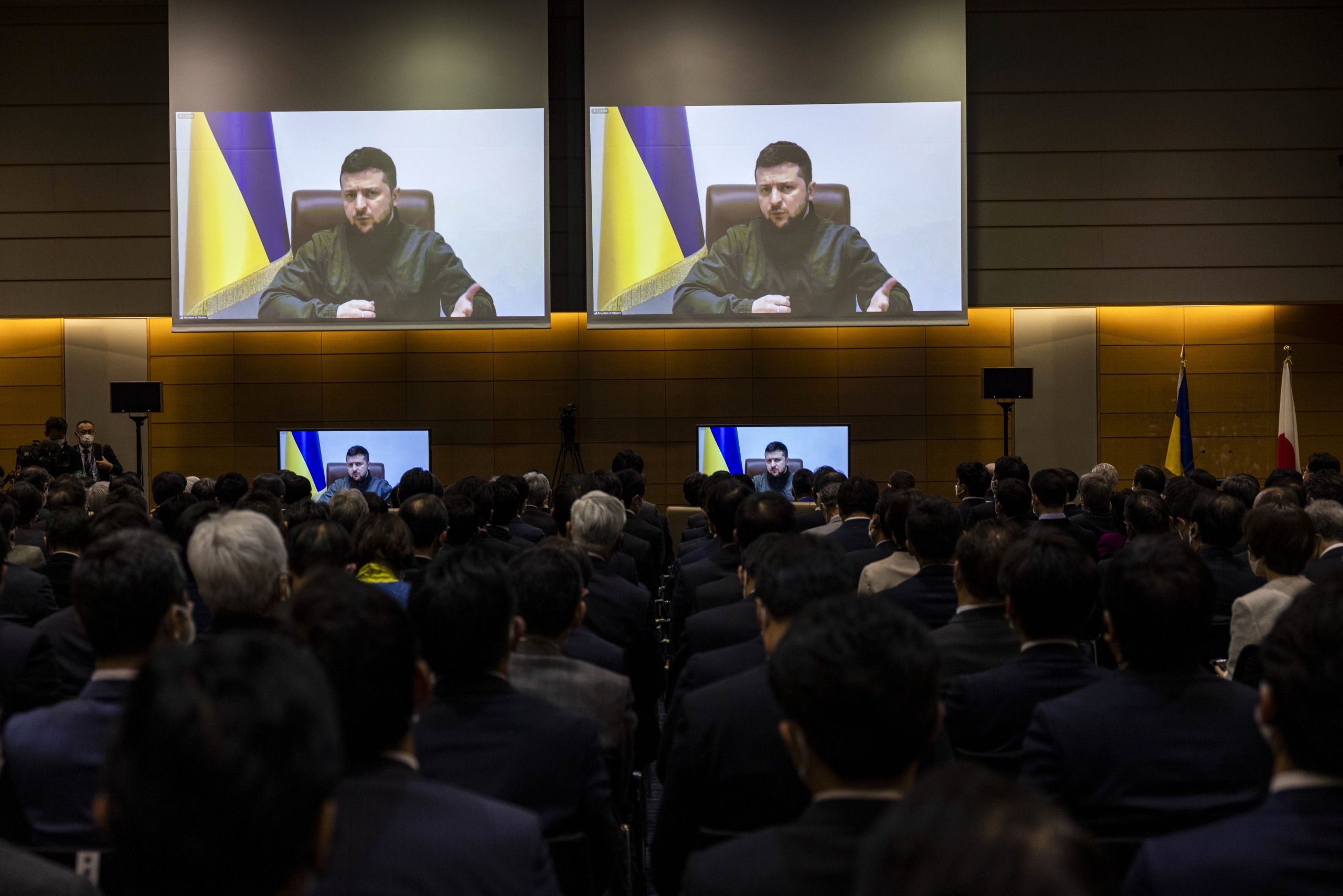 epa09843662 Ukrainian President Volodymyr Zelensky (on screen) addresses Japan's lower house lawmakers during a videoconference at the House of Representatives office building in Tokyo, Japan, 23 March 2022.  EPA/BEHROUZ MEHRI / POOL