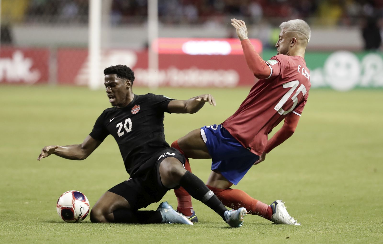 epa09848168 Francisco Calvo (R) of Costa Rica in action against Jonathan David (L) of Canada during the CONCACAF 2022 World Cup Qatar qualifier soccer match between Costa Rica and Canada, at the National Stadium in San Jose, Costa Rica, 24 March 2022.  EPA/Jeffrey Arguedas