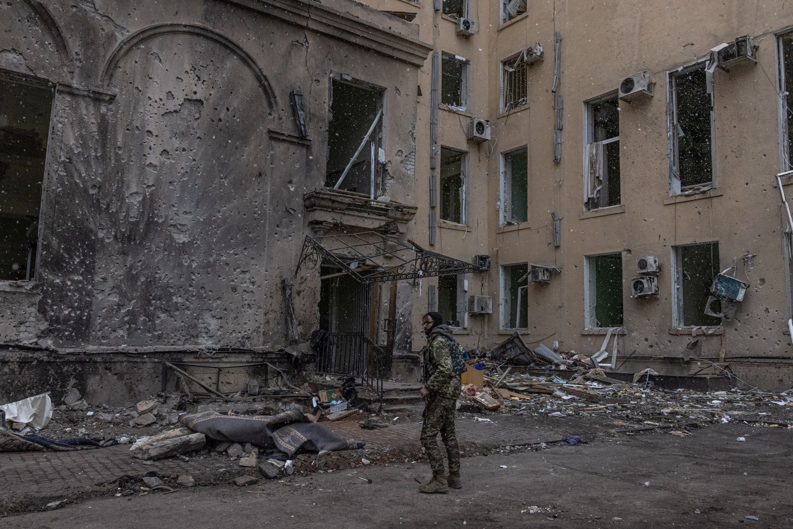 epa09853210 A member of the Ukrainian military stands next to the damaged building of Kharkiv Regional State Administration, that was heavily shelled by Russian forces, in Kharkiv, northeast Ukraine, 27 March 2022. The building was heavily shelled on 01 March, and the searching operation for victims is still going on. The bodies of 24 people have been found under the rubble, according to the information provided by Ukrainian State Emergency Service. Kharkiv, Ukraine’s second-largest city of 1.5 million people, which lies about 25 miles from the Russian border, has been heavily shelled by Russian forces over the past weeks, with many civilians killed in the city.  EPA/ROMAN PILIPEY