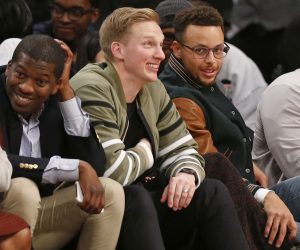 Stephen Curry, right, sits with his chief marketing office Jeron Smith, left, and social media guru and Davidson roommate Bryant Barr, center, as the trio watches during the second half of an NCAA college basketball game between Penn State and Pittsburgh in the Legends Classic, Monday, Nov. 20, 2017, in New York. Penn State defeated Pittsburgh 85-54. (AP Photo/Kathy Willens)