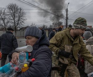 epa09840161 (FILE) - An elderly woman receives water and cleaning products distributed by Ukrainian military members to local residents as behind is seen smoke from a shelling, in Irpin city, Kyiv (Kiev) province, Ukraine, 03 March 2022 (reissued 21 March 2022). Since Russia invaded Ukraine one month ago on 24 February 2022, more than three million Ukrainians became refugees, around 700 civilians were killed and over 1.000 more injured, the United Nations said.  EPA/ROMAN PILIPEY  ATTENTION: This Image is part of a PHOTO SET