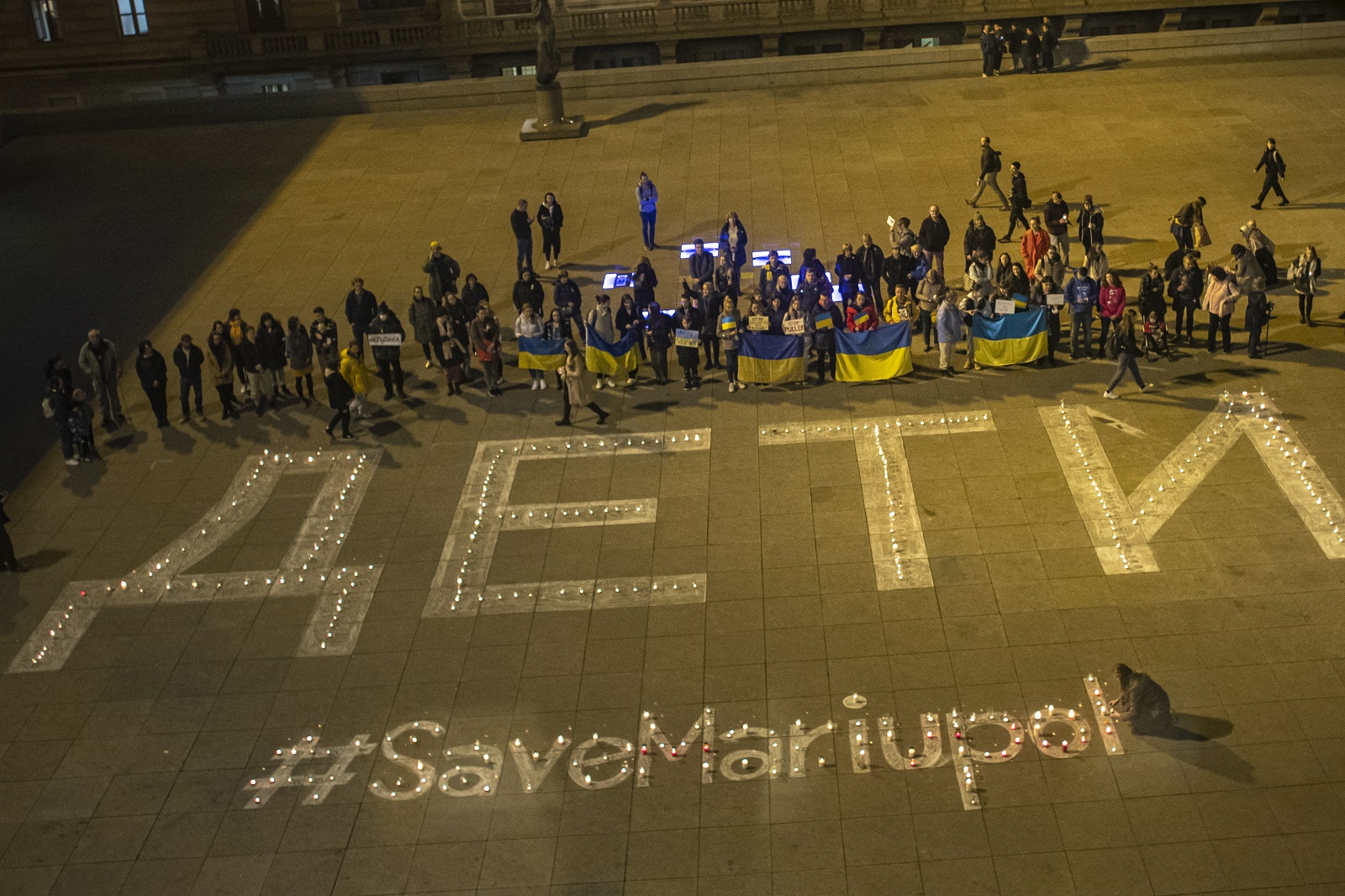 epa09843117 People light candles during the Light for Mariupol peace rally for people who died during a shelling in the eastern Ukrainian city of Mariupol, in front of the National Theatre building in Prague, Czech Republic, 22 March 2022. People created a large luminous sign ‘ДЕТИ’, which means 'children' in Russian, the same sign that was meant to protect the theatre in Mariupol against a bomb attack. At least 30 people were killed and about 100 others injured during this large-scale attack.  EPA/MARTIN DIVISEK