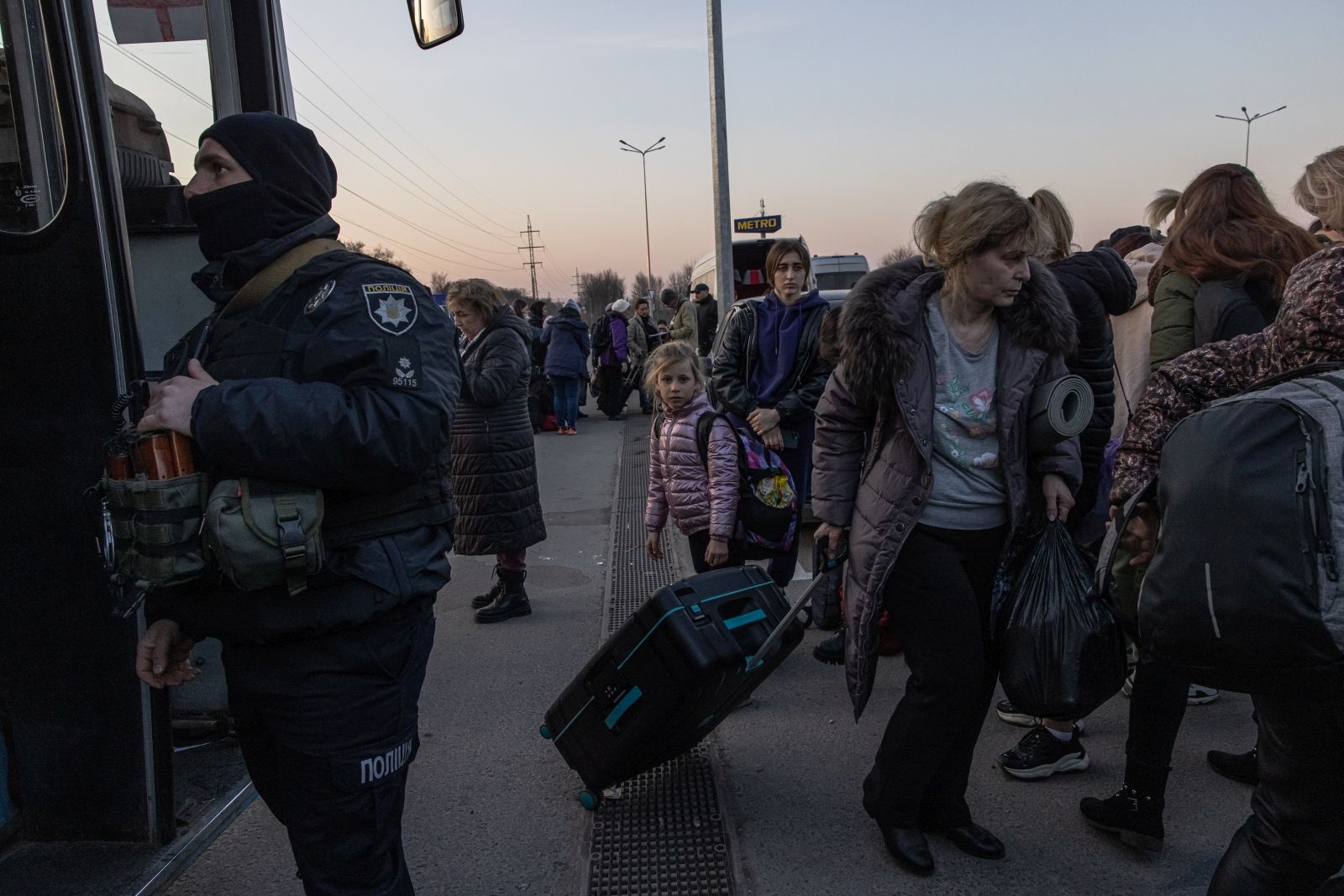 epa09850008 People who fled from the besieged by Russian military southeastern city of Mariupol and occupied Melitopol gather after arriving at the evacuation point in Zaporizhzhia, Ukraine, 25 March 2022. Hundreds of people were evacuated on 25 March from the southeastern cities of Mariupol and Melitopol and arrived in Ukraine's controlled area by buses and their own cars. Almost 100,000 residents remain trapped and live in 'inhuman conditions' without food and water in the ruined city of Mariupol, amid Russia's 'constant shelling', Ukrainian president Volodymyr Zelenskyy says.  EPA/ROMAN PILIPEY