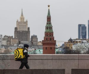 epa09857475 A delivery man walks on on a bridge near the Kremlin in Moscow, Russia, 29 March 2022.  EPA/YURI KOCHETKOV