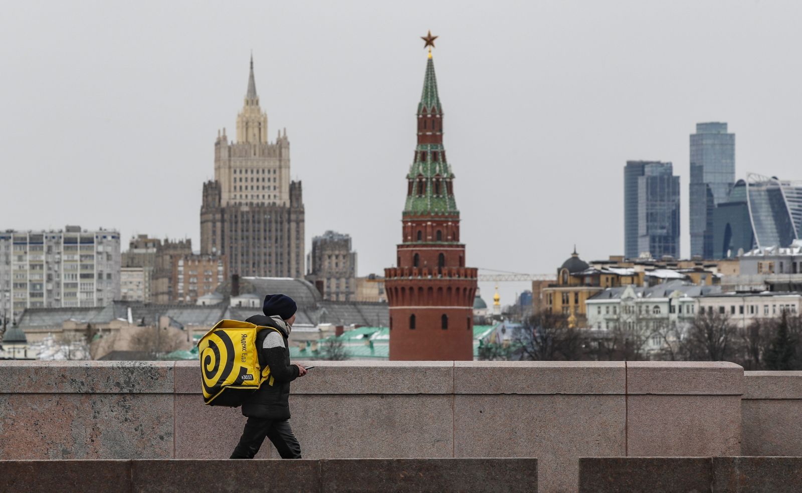epa09857475 A delivery man walks on on a bridge near the Kremlin in Moscow, Russia, 29 March 2022.  EPA/YURI KOCHETKOV