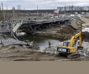 epa09873518 Ukrainians build a new bridge (R) over a river near the damaged old bridge (L) outside the recaptured city of Irpin, Ukraine, 06 April 2022. Ukrainian forces have recently recaptured from the Russian army some cities and villages in the outskirts of Kyiv.  EPA/OLEG PETRASYUK