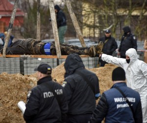 epa09878613 Police officers remove a body from a mass grave discovered in Bucha, outskirts of Kyiv (Kiev), Ukraine, 08 April 2022. Ukrainian authorities say that over 400 bodies were discovered following the Russian army’s retreat from towns surrounding Kyiv, prompting international calls for a probe into possible war crimes committed by Russia.  EPA/OLEG PETRASYUK