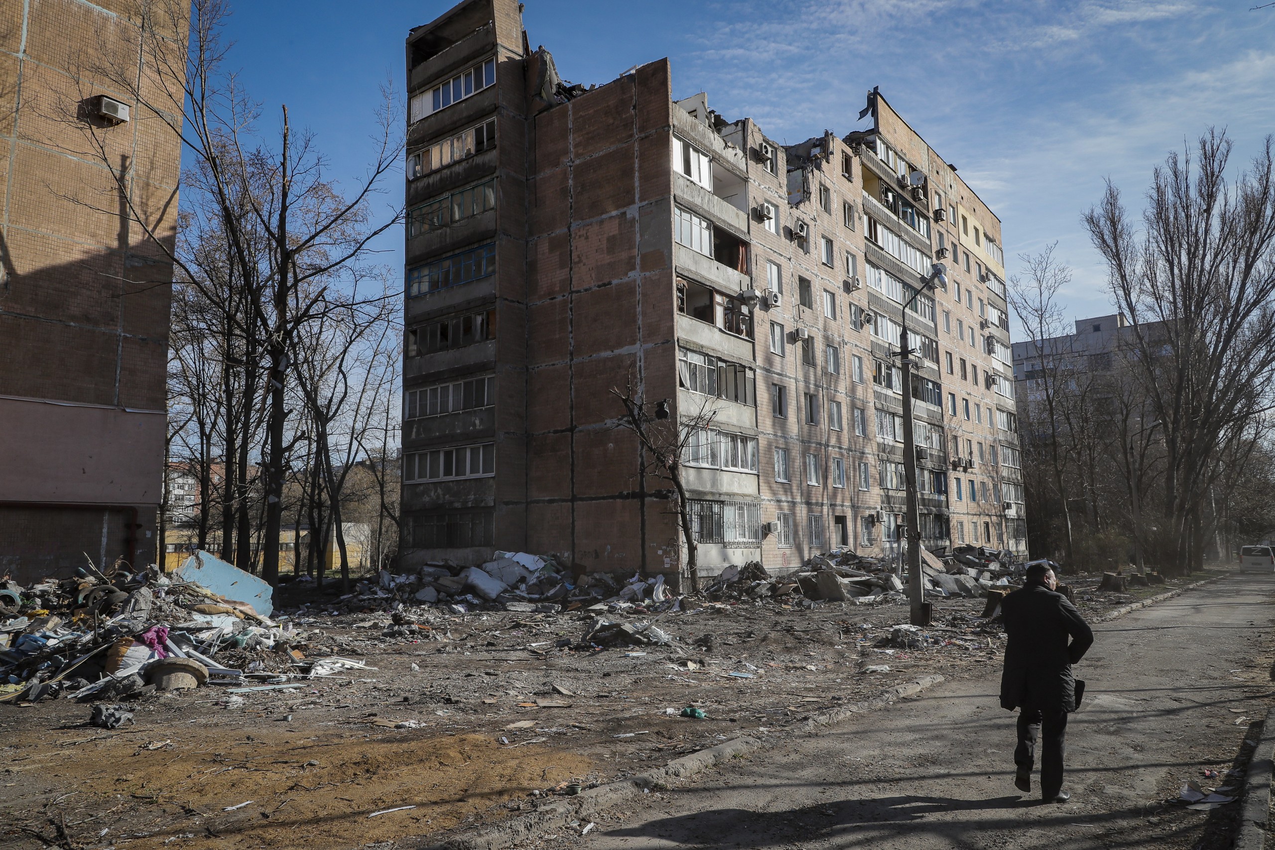 epa09884757 A local man walks near the place where, two weeks ago, an apartment building was destroyed as a result of a 'Uragan' missile hit, in Donetsk, Ukraine, 11 April 2022. In the self-proclaimed Donetsk People's Republic (DPR), 261 people died from 01 April to 07 April, the press service of the Commissioner for Human Rights in the republic reports. In total, 6,271 deaths have been registered in the DPR since the spring of 2014, including 96 children. On 24 February Russian troops had entered Ukrainian territory in what the Russian president declared a 'special military operation', resulting in fighting and destruction in the country, a huge flow of refugees, and multiple sanctions against Russia.  EPA/SERGEI ILNITSKY