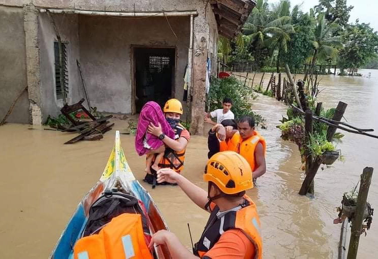 epa09885400 A handout photo made available by the Philippine Coast Guard (PCG) shows a rescuer carries a boy in a rubber boat on a flooded village in Roxas city, Capiz province, Panay island, Philippines, 12 April 2022. According to local authorities reports, scores of villagers were burried from landslides in the central and southern Philippines brought by Typhoon Megi.  EPA/PCG / HANDOUT BEST QUALITY AVAILABLE HANDOUT EDITORIAL USE ONLY/NO SALES