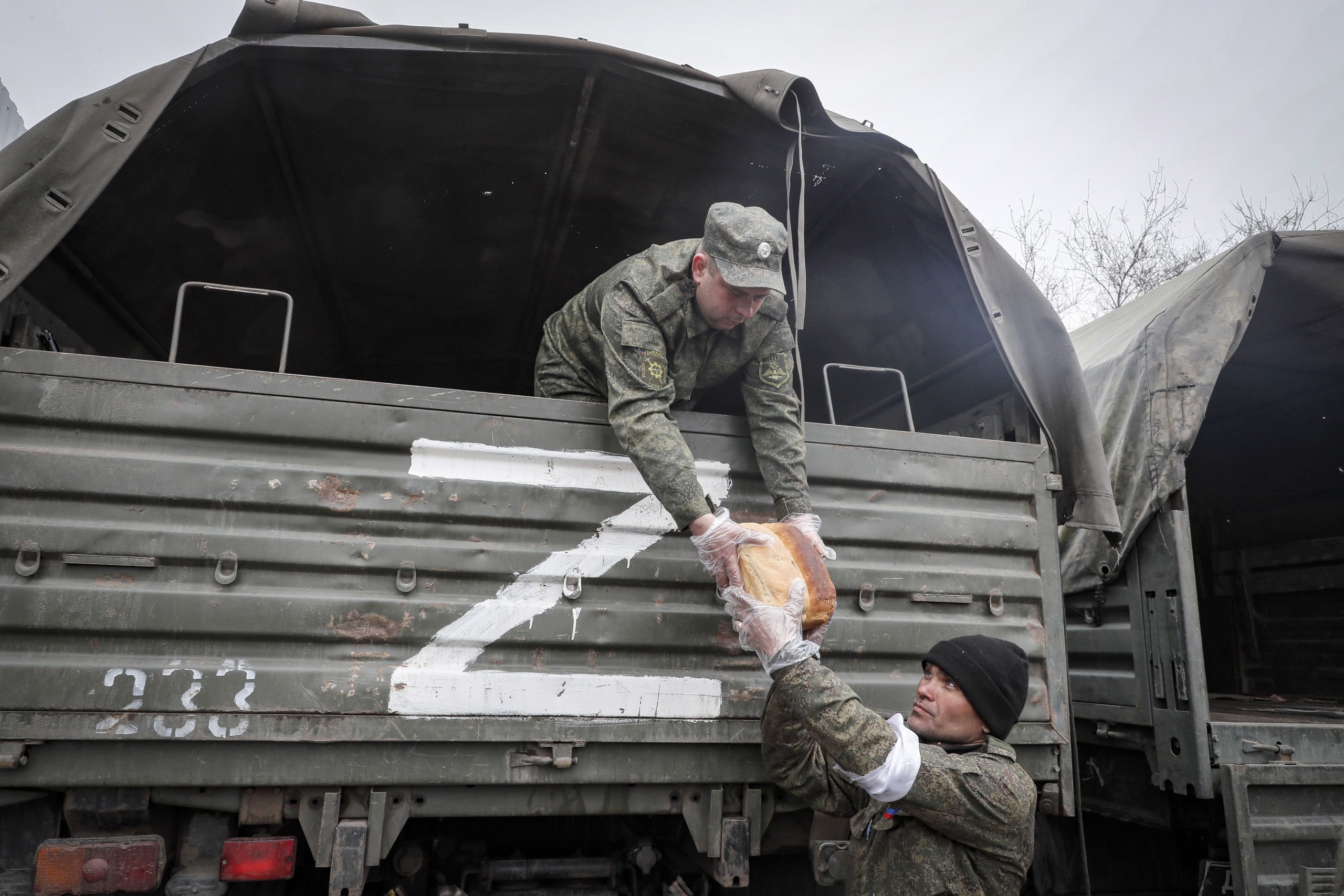 epa09886129 A picture taken during a visit to Mariupol organized by the Russian military shows militias of self-proclaimed DPR unload bread during a distribution of humanitarian aid to local people in Mariupol, Ukraine, 12 April 2022. Some 133,214 people, including two thousand people over the past day, left Mariupol through the gum corridor in the eastern direction, according to the head of the Russian National Defense Control Center. The main battles in the central part of Mariupol are over, said the representative of the people's militia of the self-proclaimed Donetsk People's Republic (DPR). On 24 February Russian troops had entered Ukrainian territory in what the Russian president declared a 'special military operation', resulting in fighting and destruction in the country, a huge flow of refugees, and multiple sanctions against Russia.  EPA/SERGEI ILNITSKY