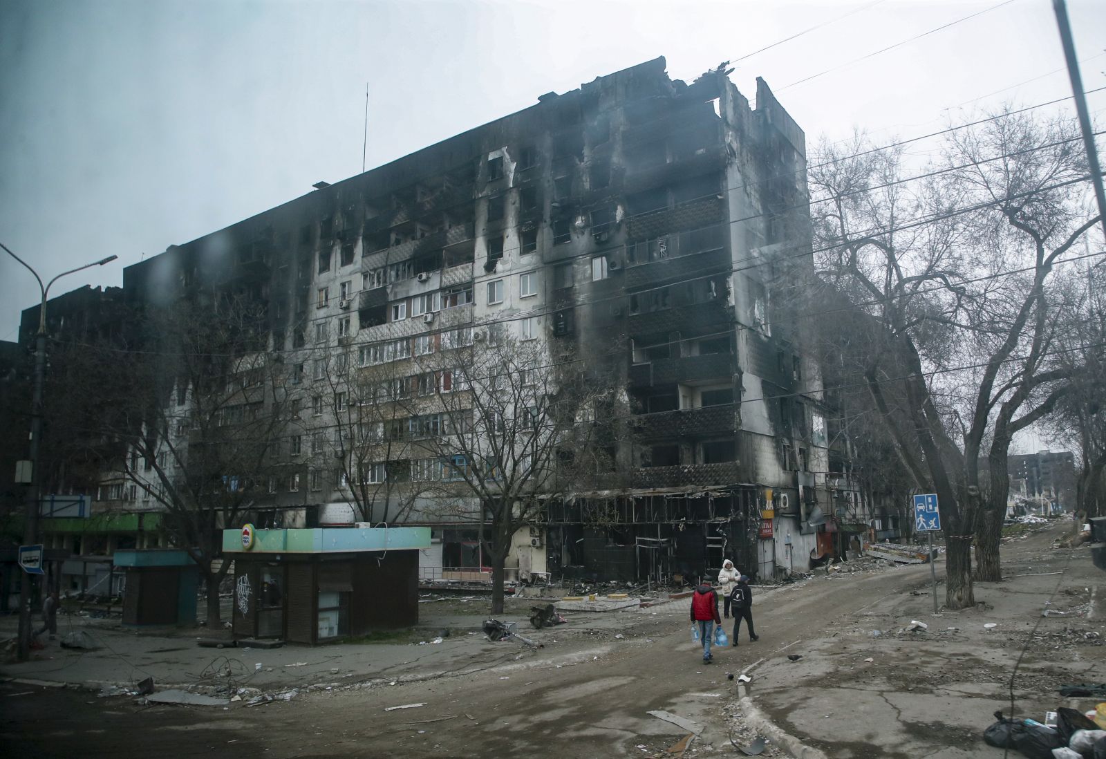 epa09887016 A picture taken during a visit to Mariupol organized by the Russian military shows local people cary water near devesteted and burned apartment building in downtown Mariupol, Ukraine, 12 April 2022. For more than a month, hostilities have continued in the city. There is no water, electricity, gas or communications. Shops, pharmacies and hospitals are closed. 250 thousand inhabitants left the city, about 300 thousand still remain. During the hostilities, up to 70 percent of the housing stock of Mariupol was destroyed and five thousand residents of the city was killed said the new mayor of the city Konstantin Ivashchenko. On 24 February Russian troops had entered Ukrainian territory in what the Russian president declared a 'special military operation', resulting in fighting and destruction in the country, a huge flow of refugees, and multiple sanctions against Russia.  EPA/SERGEI ILNITSKY