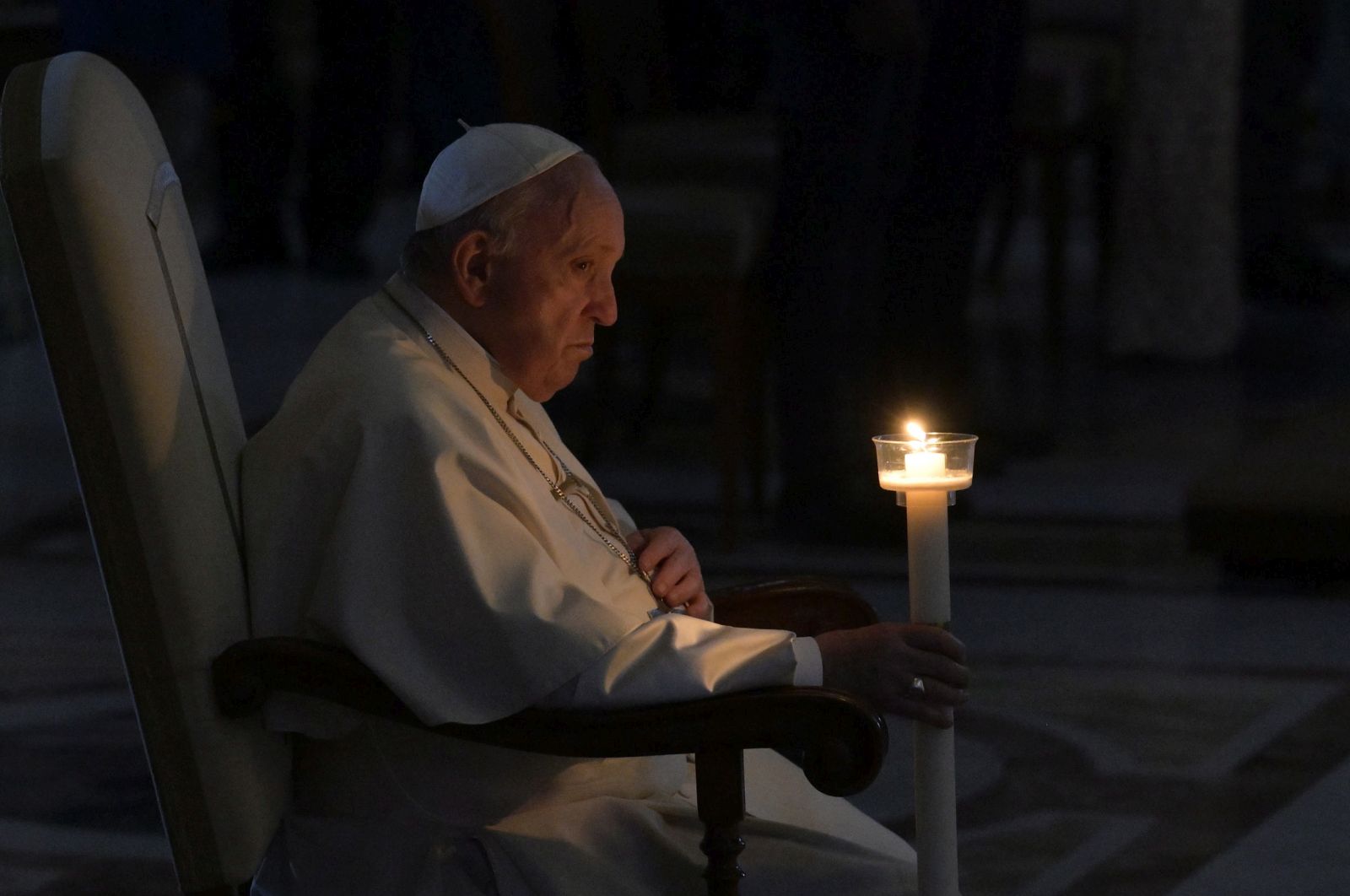 epa09893645 Pope Francis holds a candle as he attends the Easter Vigil Mass in Saint Peter's Basilica at the Vatican, 16 April 2022.  EPA/CLAUDIO PERI