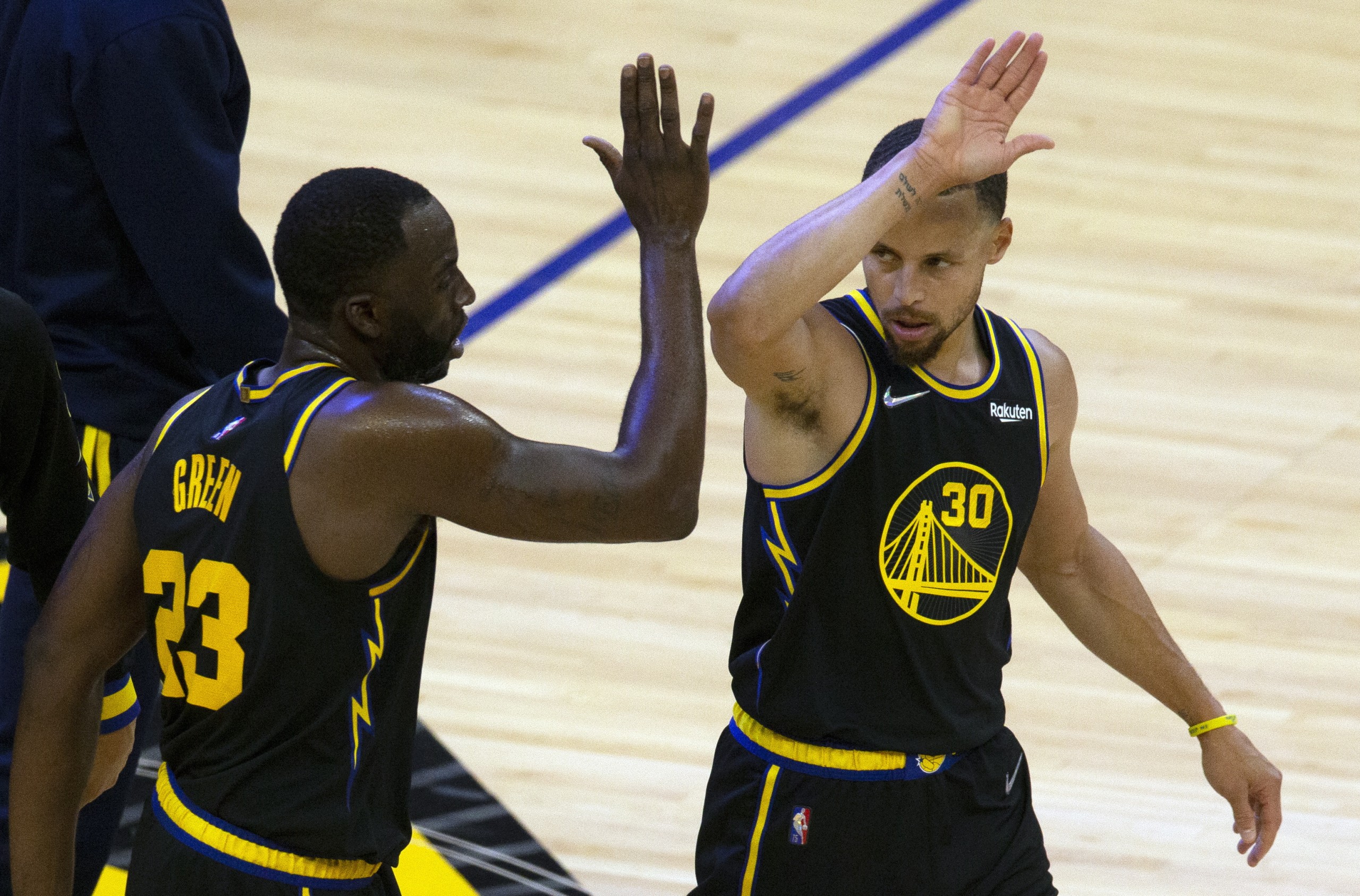 epa09894082 Golden State Warriors forward Draymond Green (L) high fives teammate Stephen Curry during the second quarter of the NBA basketball game between the Denver Nuggets and the Golden State Warriors at Chase Center in San Francisco, California, USA, 16 April 2022.  EPA/D. ROSS CAMERON  SHUTTERSTOCK OUT