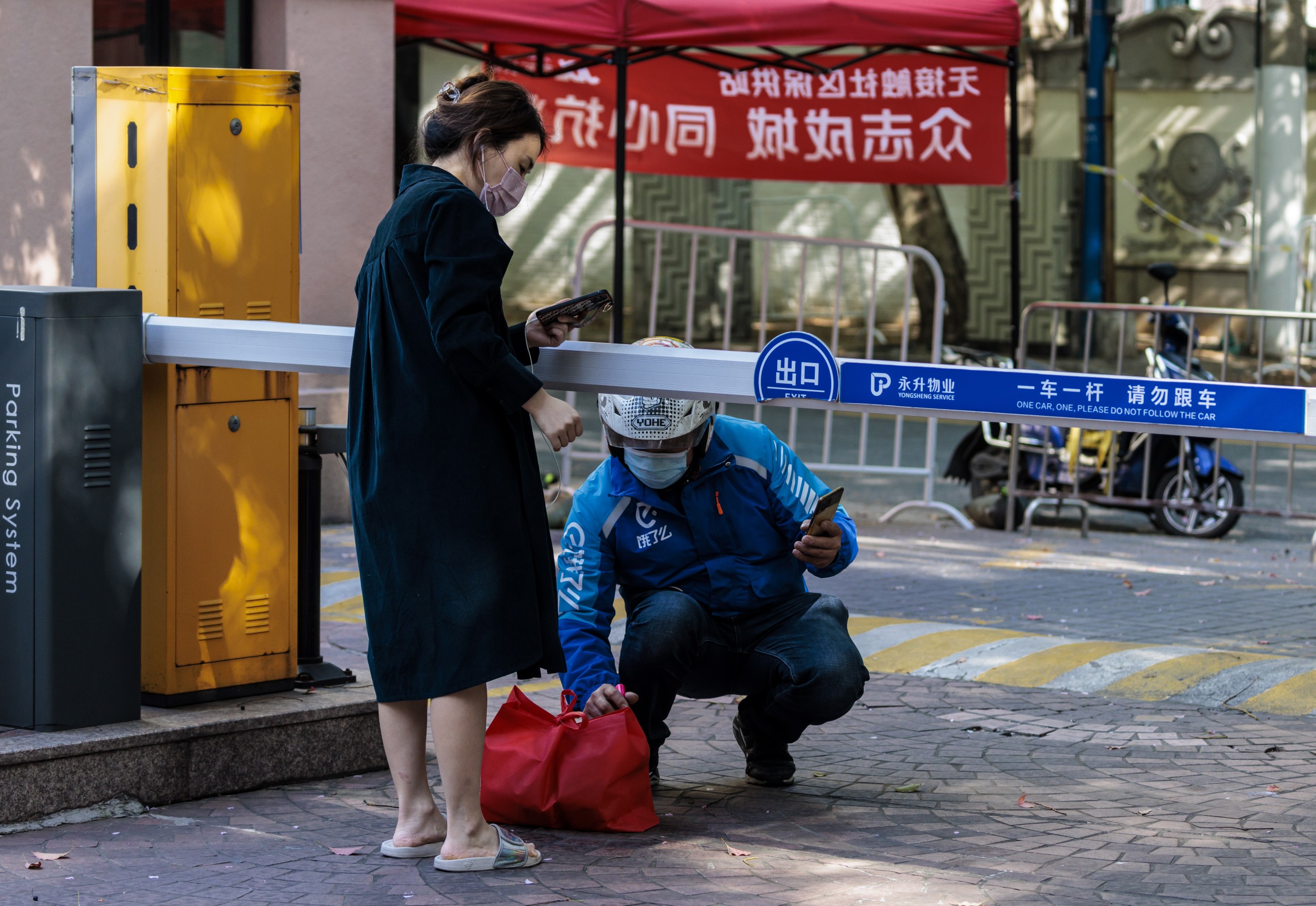 epa09895611 A woman under quarantine receives delivery in a residential community under lockdown in Shanghai, China, 18 April 2022. On 18 April 2022, in Shanghai city, there were 2.417  new locally transmitted COVID-19 cases and 19.831 local asymptomatic infections, and new local fatalities, according to the Shanghai Health Commission. On 1 April 2022, the city went into the general lockdown for 4 days. Those 4 days turned into 18 days and counting. Some of the residential buildings got released, however, the majority is still locked. Most delivery services are blocked off, leading people to fight against hunger with lack of possibility to buy groceries, and get medical care for non-Covid related diseases.  EPA/ALEX PLAVEVSKI