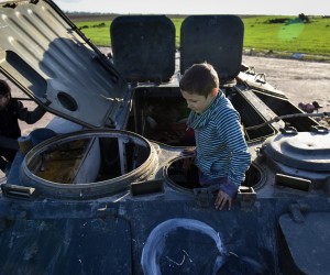 epa09913389 Local boys named Fadey and Bohdan, play in a damaged Russian APC in Lukashivka village, Chernihiv region, 27 April 2022. On 24 February, Russian troops entered Ukrainian territory in what the Russian president declared a 'special military operation', resulting in fighting and destruction in the country, a huge flow of refugees, and multiple sanctions against Russia.  EPA/OLEG PETRASYUK