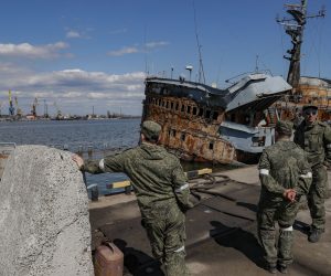 epa09917499 A picture taken during a visit to Mariupol organized by the Russian military shows Russian servicemen stand in front of the sunken control ship 'Donbass' of the Ukrainian Navy in the territory of the cargo sea port in Mariupol, Ukraine, 29 April 2022. Mariupol is located on the northern coast of the Sea of Azov, it is one of the largest commercial seaports in Ukraine. Almost 500 thousand people previously lived in the city. On 16 April, the Russian Defense Ministry announced that the urban area of Mariupol had been cleared of the Ukrainian military, and their remnants were completely blocked on the territory of the Azovstal metallurgical plant. On 24 February Russian troops had entered Ukrainian territory in what the Russian president declared a 'special military operation', resulting in fighting and destruction in the country, a huge flow of refugees, and multiple sanctions against Russia.  EPA/SERGEI ILNITSKY
