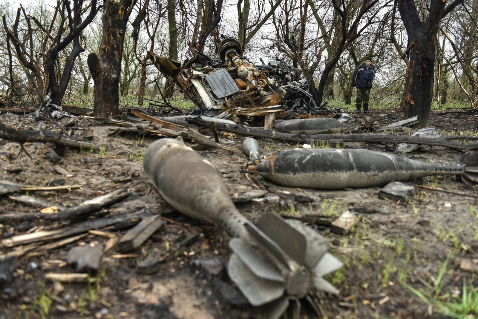 epa09898952 A local man looks at rest of bombs that litters a field in Ivanivka village, Chernihiv region, UKraine, 20 April 2022. On 24 February Russian troops had entered Ukrainian territory resulting in fighting and destruction in the country, a huge flow of refugees, and multiple sanctions against Russia.  EPA/OLEG PETRASYUK