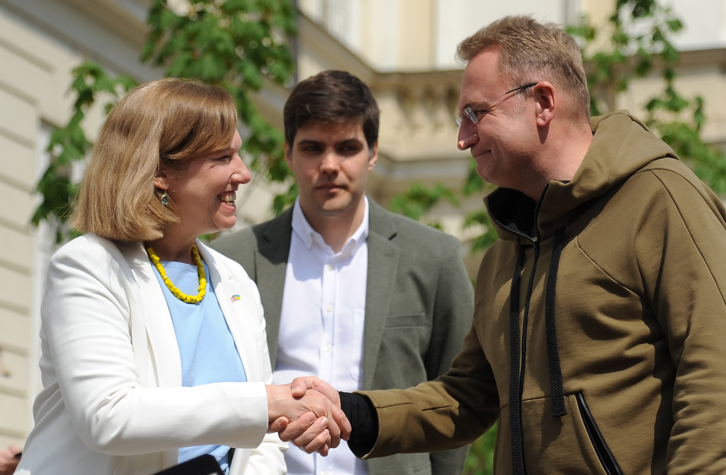 epa09922732 Acting US ambassador to Ukraine Kristina Kvien (L) shakes hands with Mayor of Lviv Andriy Sadovyi (R) during a press briefing in downtown Lviv, Ukraine, 02 May 2022. Kvien said that Washington hopes to return to the Ukrainian capital Kyiv to open its embassy by the end of May.  EPA/MYKOLA TYS