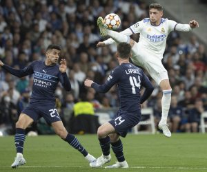 epa09926995 Real Madrid's midfielder Fede Valverde (R) in action against Manchester City's defender Aymeric Laporte (C) and Joao Cancelo (L) during the UEFA Champions League semifinal second leg soccer match between Real Madrid and Manchester City held at Santiago Bernabeu Stadium, in Madrid, Spain, 04 May 2022.  EPA/Rodrigo Jimenez