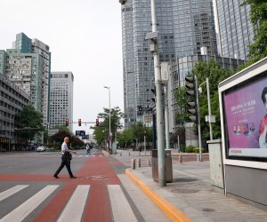 epa09927709 A man crosses a road in the central business district of Beijing, China, 05 May 2022. Beijing urged its residents to work from home following the May Day holiday in an attempt to curb the spread of COVID-19. Dozens of subway stations and bus routes in Beijing shut down and most food establishments with their dine-in services were banned.  EPA/MARK R. CRISTINO