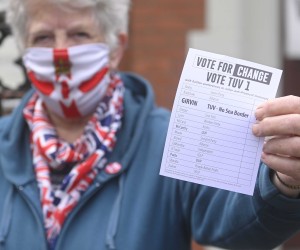 epa09928561 A woman hands out leaflets in support of the TUV [Traditional Unionist Voice] in Belfast, Northern Ireland, 05 May 2022.  Polling stations across Northern Ireland are open for voting for the 2022 Assembly Election.  EPA/MARK MARLOW