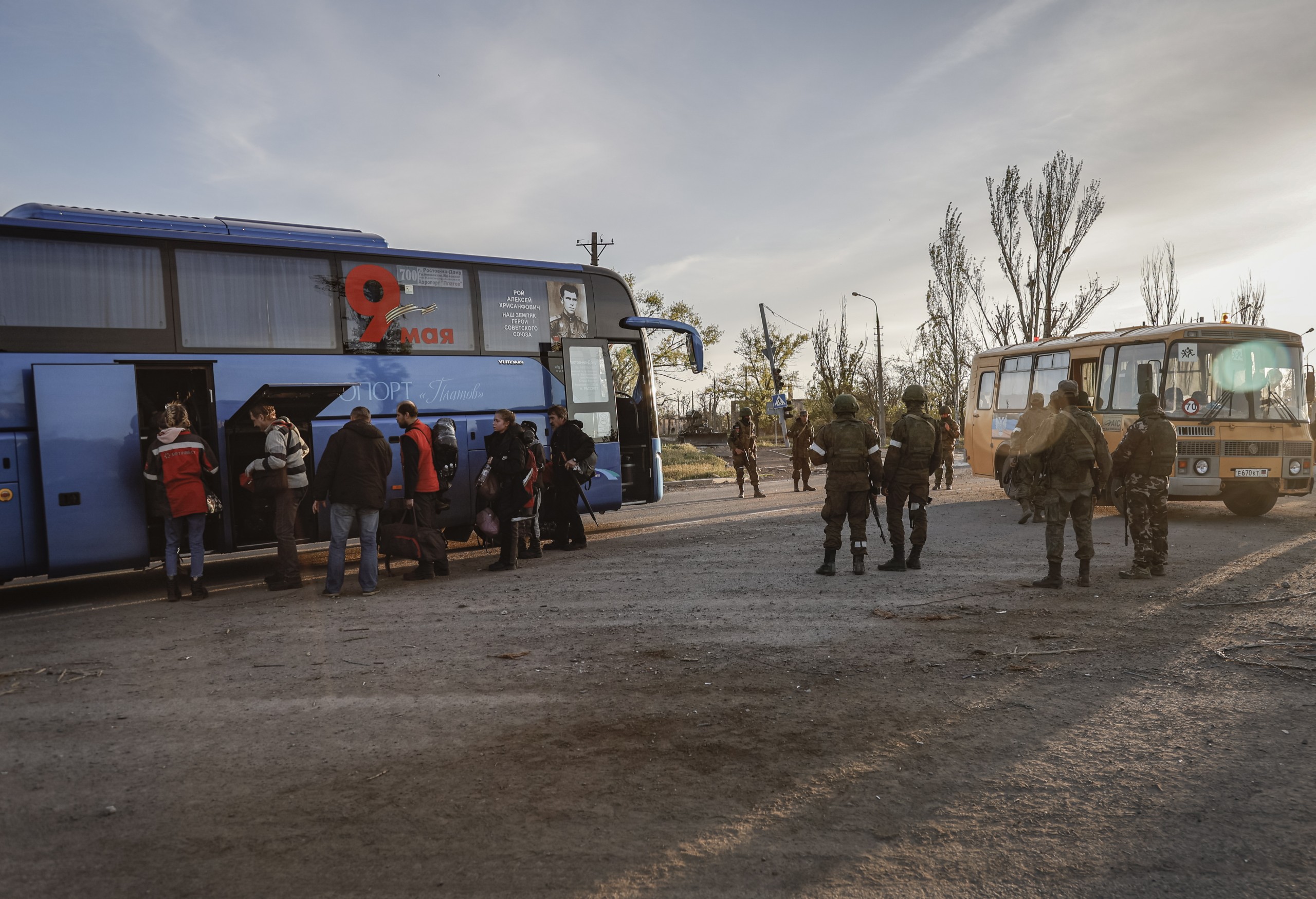 epa09930809 Russian servicemen control the boarding of a bus by the civilian people who were evacuated from Azovstal in Mariupol, Ukraine, 06 May 2022.  According to the Interdepartmental Coordinating Headquarters of the Russian Federation for Humanitarian Response, 50 civilians, including 11 children, were evacuated from a bomb shelter at the Azovstal plant. On 24 February, Russian troops had entered Ukrainian territory in what the Russian president declared a 'special military operation', resulting in fighting and destruction in the country. According to data released by the United Nations High Commission for the Refugees (UNHCR) on 05 May, over 5.7 million refugees have fled Ukraine seeking safety, protection and assistance in neighboring countries.  EPA/ALESSANDRO GUERRA
