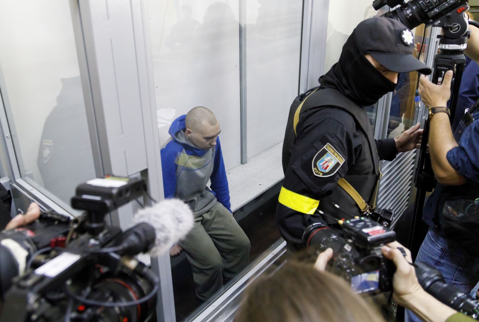 epa09944451 Russian serviceman Vadim Shishimarin (C) attends a court hearing in the Solomyansky district court in Kyiv, Ukraine, 13 May 2022. Vadim Shishimarin (21) is accused of killing an unarmed 62-year-old civilian man as Shishimarin fled with four other soldiers near Chupakha village in the Sumy area. Ukraine is holding the first war crimes trial amid the Russian invasion. Shishimarin faces possible life imprisonment if found guilty as the prosecutor's general office said.  EPA/TANYA GORDIENKO