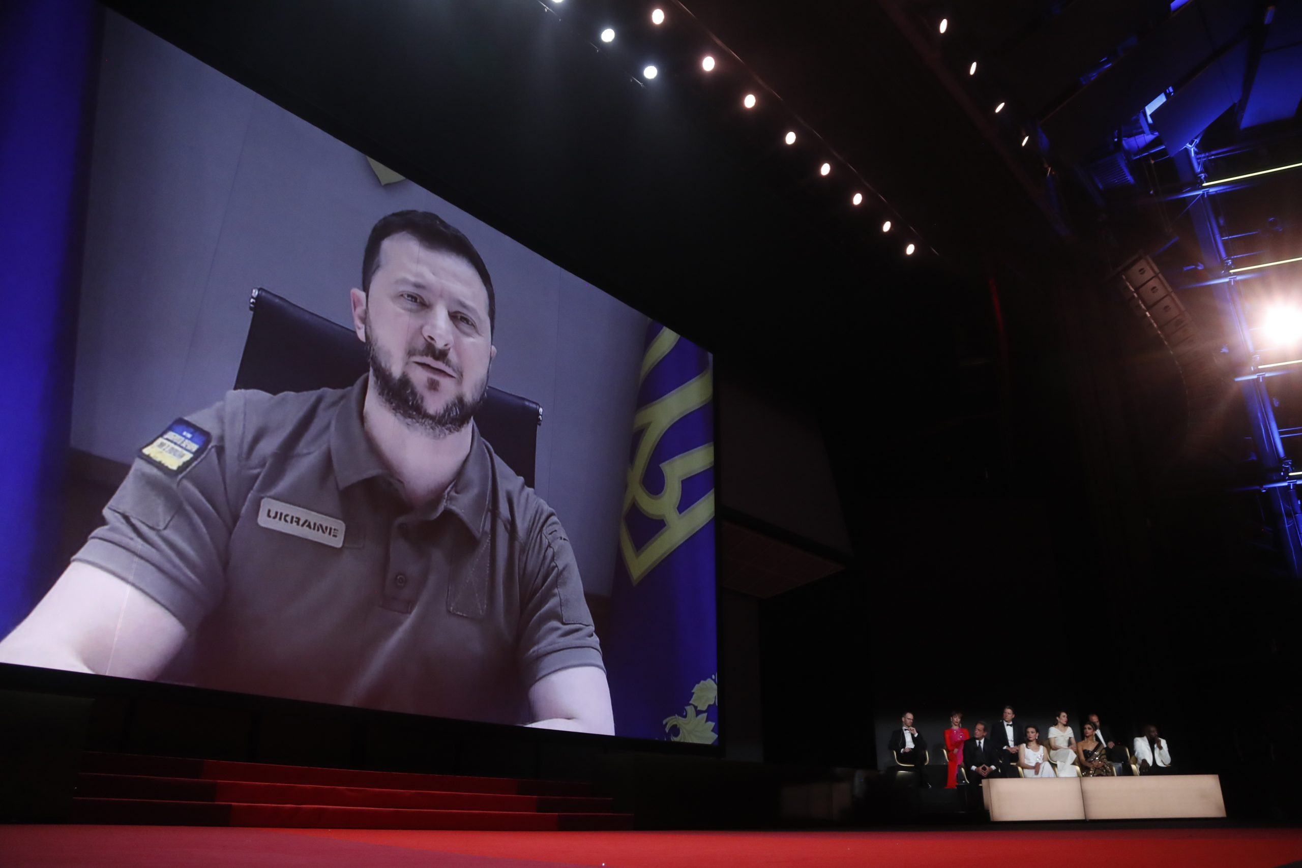 epa09953464 Ukraine's President Volodymyr Zelensky appears via remote on a screen during the Opening Ceremony of the 75th annual Cannes Film Festival, in Cannes, France, 17 May 2022. The festival runs from 17 to 28 May.  EPA/GUILLAUME HORCAJUELO