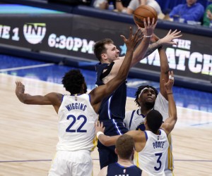 epa09968118 Dallas Mavericks guard Luka Doncic (C) makes a layup past Golden State Warriors forward Andrew Wiggins (L) and Golden State Warriors center Kevon Looney (R) and Golden State Warriors guard Jordan Poole (2-L) during the second half of the NBA Western Conference Finals playoff game three between the Dallas Mavericks and the Golden State Warriors at the American Airlines Center in Dallas, Texas, USA, 22 May 2022.  EPA/ADAM DAVIS SHUTTERSTOCK OUT