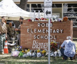 epa09976022 A man kneels by a memorial of flowers at the scene of a mass shooting at the Robb Elementary School in Uvalde, Texas, USA, 25 May 2022. According to Texas officials, at least 19 children and two adults were killed in the shooting. The eighteen-year-old gunman was killed by responding officers.  EPA/TANNEN MAURY