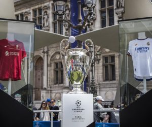 epa09977188 The Champions League's trophy displayed between Liverpool and Madrid's jerseys in a fan zone in Paris, France, 26 May 2022. Paris hosts the UEFA Champions League final between Real Madrid and Liverpool FC in 28 May 2022.  EPA/CHRISTOPHE PETIT TESSON