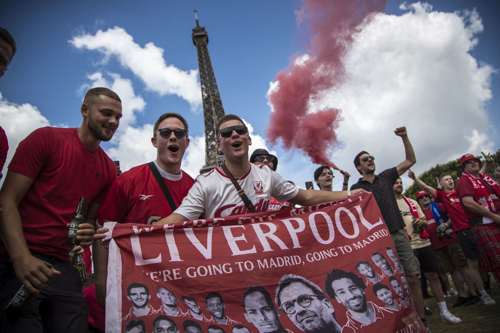 epa09981692 Liverpool's fans cheer for their team as they gather near the Eiffel Tower (rear) ahead of the UEFA Champions League final in Paris, France, 28 May 2022. Paris hosts the UEFA Champions League final between Real Madrid and Liverpool FC on 28 May 2022.  EPA/CHRISTOPHE PETIT TESSON