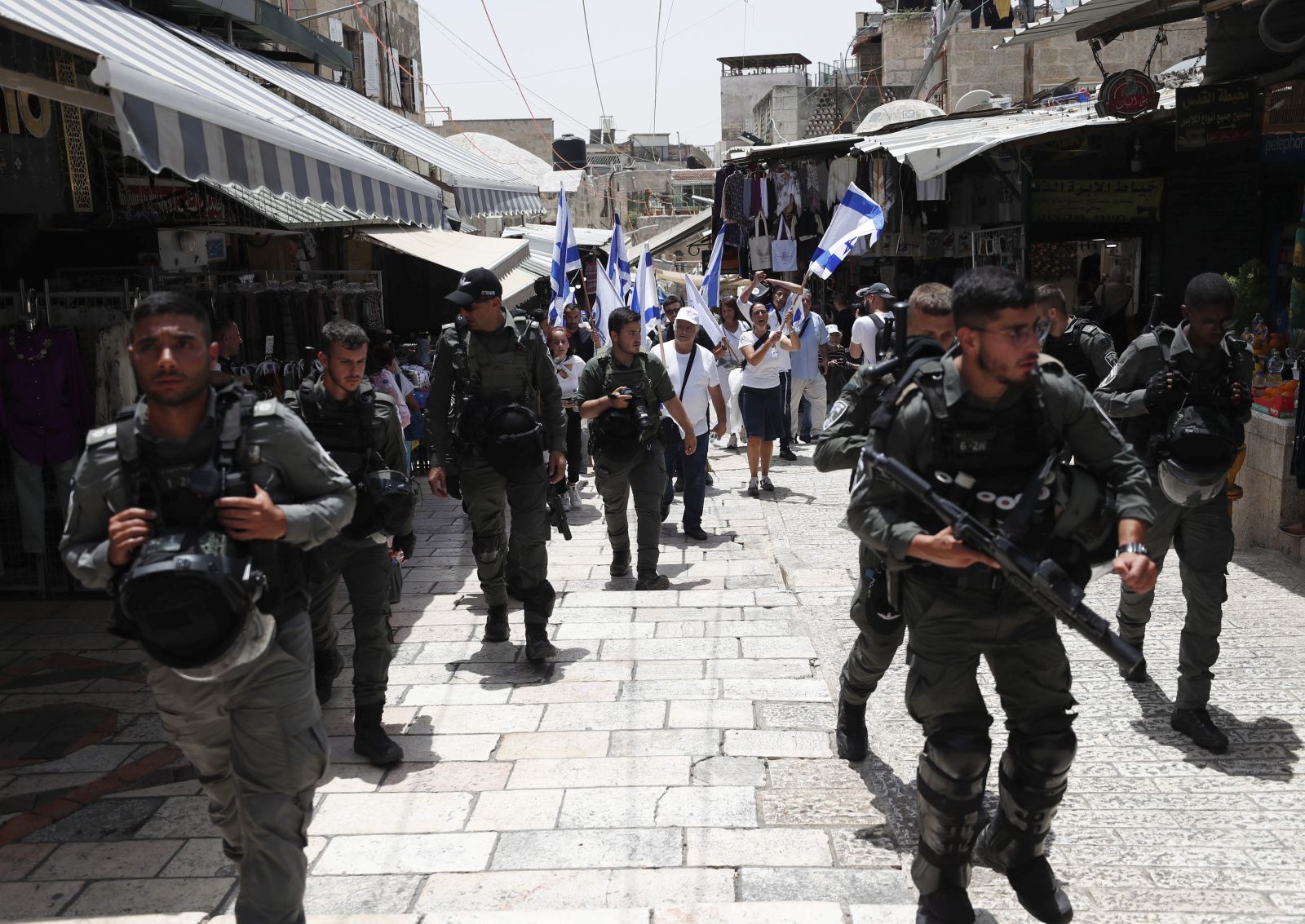 epa09983776 Israeli security forces guard participants during the Israeli right-wing 'Flag March' in the Jerusalem's Old City, Jerusalem, 29 May 2022. The annual right-wing Israeli 'Flag March' celebrating the Jerusalem Day has long been viewed by Palestinians as a provocation. Large number of Israeli police forces have been deployed in the Old city of Jerusalem and Palestinian counter protests are expected to take place in the Gaza City and West Bank.  EPA/ATEF SAFADI