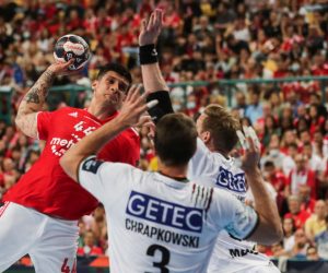 epa09985007 Benfica's Petar Djordjic (L) fights for the ball with Magdeburg's Piotr Chrapkowski (C) during the EHF European League final handball match SL Benfica vs SC Magdeburg at the Altice Arena in Lisbon, Portugal, 29 May 2022.  EPA/TIAGO PETINGA