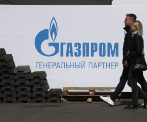 epa09980733 People walk in front of a banner with the Gazprom logo at the Dvortsovaya Square in St. Petersburg, Russia, 27 May 2022.  EPA/ANATOLY MALTSEV