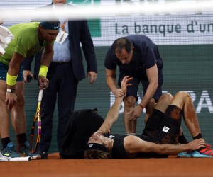 epa09994242 Alexander Zverev of Germany is injured on the court after falling in the men's semi-final match against Rafael Nadal of Spain during the French Open tennis tournament at Roland ​Garros in Paris, France, 03 June 2022.  EPA/YOAN VALAT