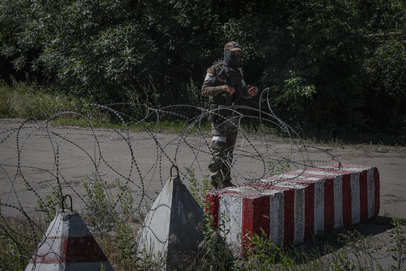 epa10008633 A picture taken during a visit to Luhansk organized by the Russian military shows a Russian serviceman guards on the road near fortified positions of the Ukrainian army captured in the battles in Schastia, Luhansk, region, Ukraine, 11 June 2022. On 24 February, Russian troops invaded Ukrainian territory starting a conflict that has provoked destruction and a humanitarian crisis. According to the UNHCR, more than six million refugees have fled Ukraine, and a further 7.7 million people have been displaced internally within Ukraine since.  EPA/SERGEI ILNITSKY