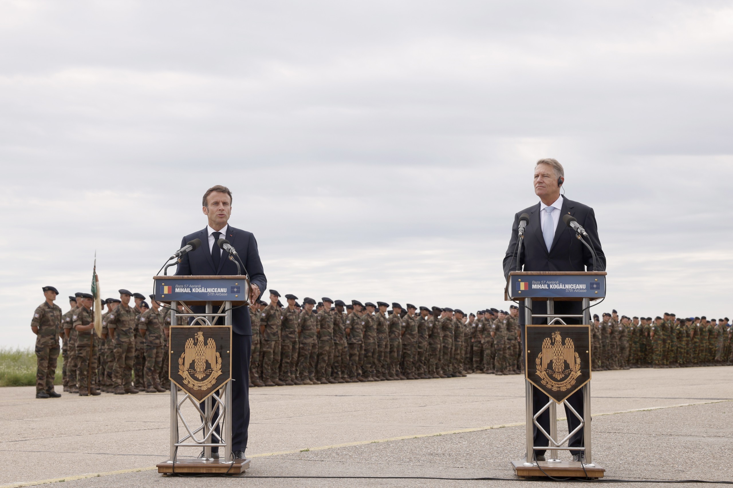 epa10013981 French President Emmanuel Macron (L) and Romanian President Klaus Iohannis (R) deliver statements as they visit NATO forces at the Mihail Kogalniceanu Air Base, near the city of Constanta, Romania, 15 June 2022. Macron is visiting Romania to hold bilateral talks and meet with NATO troops stationed at the airbase.  EPA/YOAN VALAT / POOL
