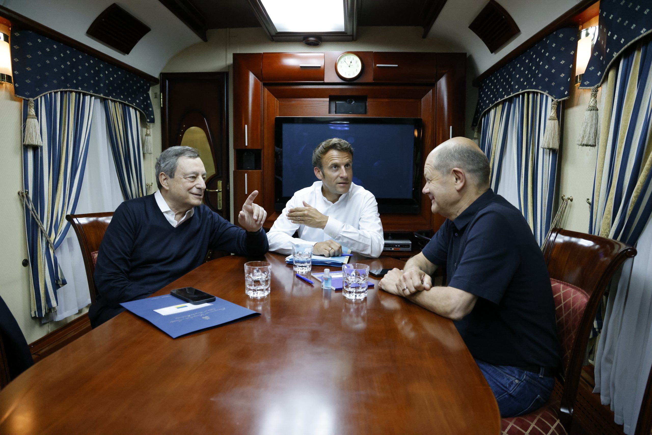 epa10015399 (L-R) Italian Prime Minister Mario Draghi, French President Emmanuel Macron and German Chancellor Olaf Scholz talk inside a train carriage at an undisclosed location on their way from Poland to Kyiv, Ukraine, 16 June 2022. The three EU leaders will meet Ukrainian President Volodymyr Zelensky.  EPA/LUDOVIC MARIN / POOL MAXPPP OUT