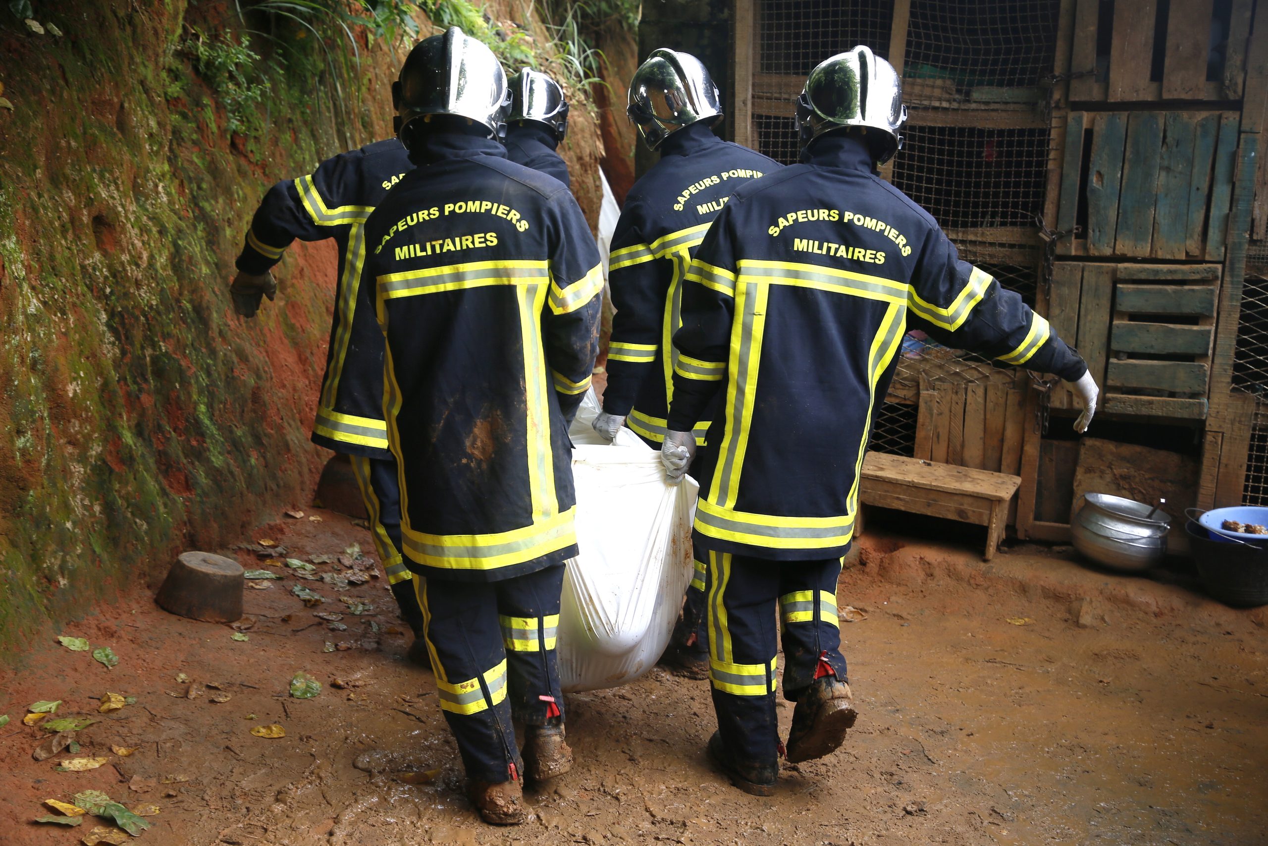 epa10016463 Rescue workers from Ivory Coast remove a body after a landslide in Attecoube, Ivory Coast, 16 June 2022. During the night of 15 to 16 June, rain fell in several districts of the city of Abidjan and the suburbs. According to a provisional report announced by military firefighters, there are 7 victims, including 5 dead and 2 injured.  EPA/LEGNAN KOULA